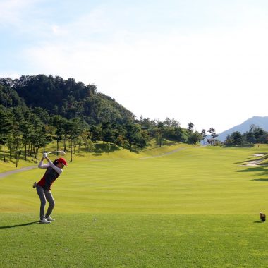 Female golfer driving down the green