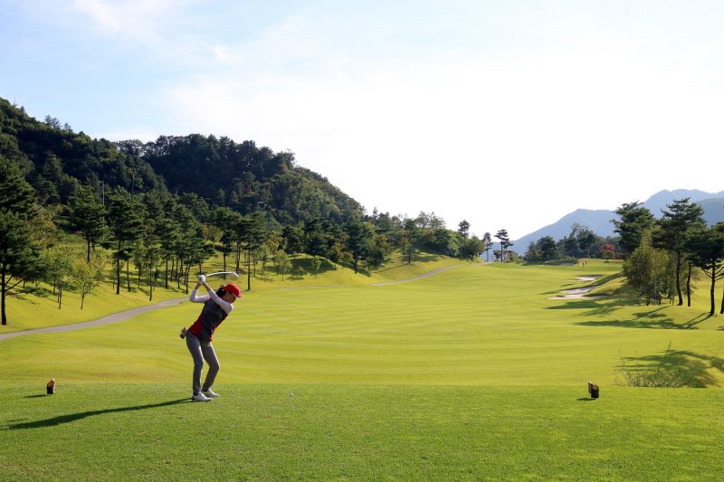 Female golfer driving down the green